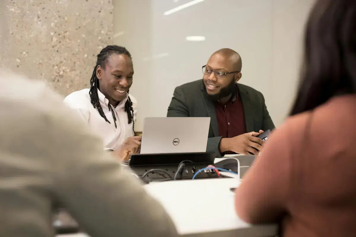 Two business partners reviewing their numbers on a laptop