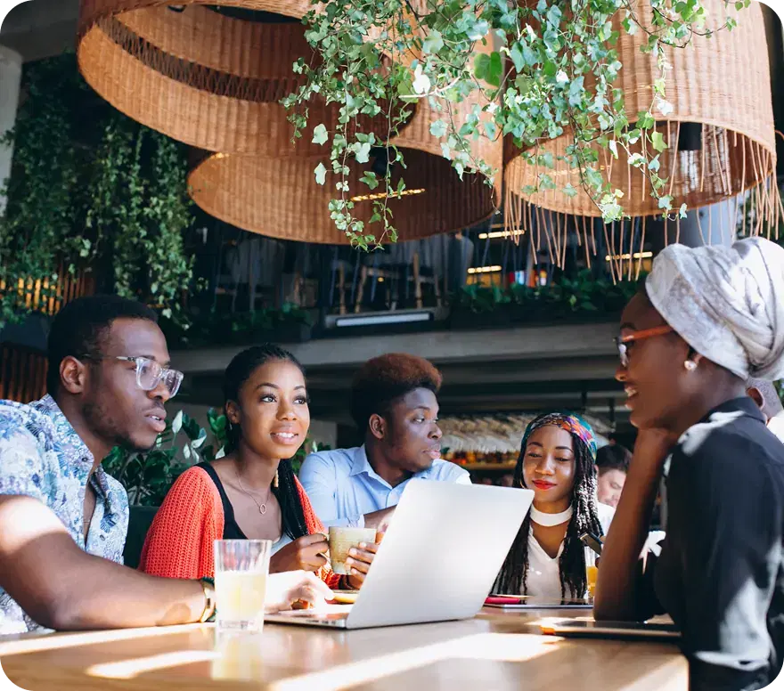 Colleagues talking around a table with a laptop