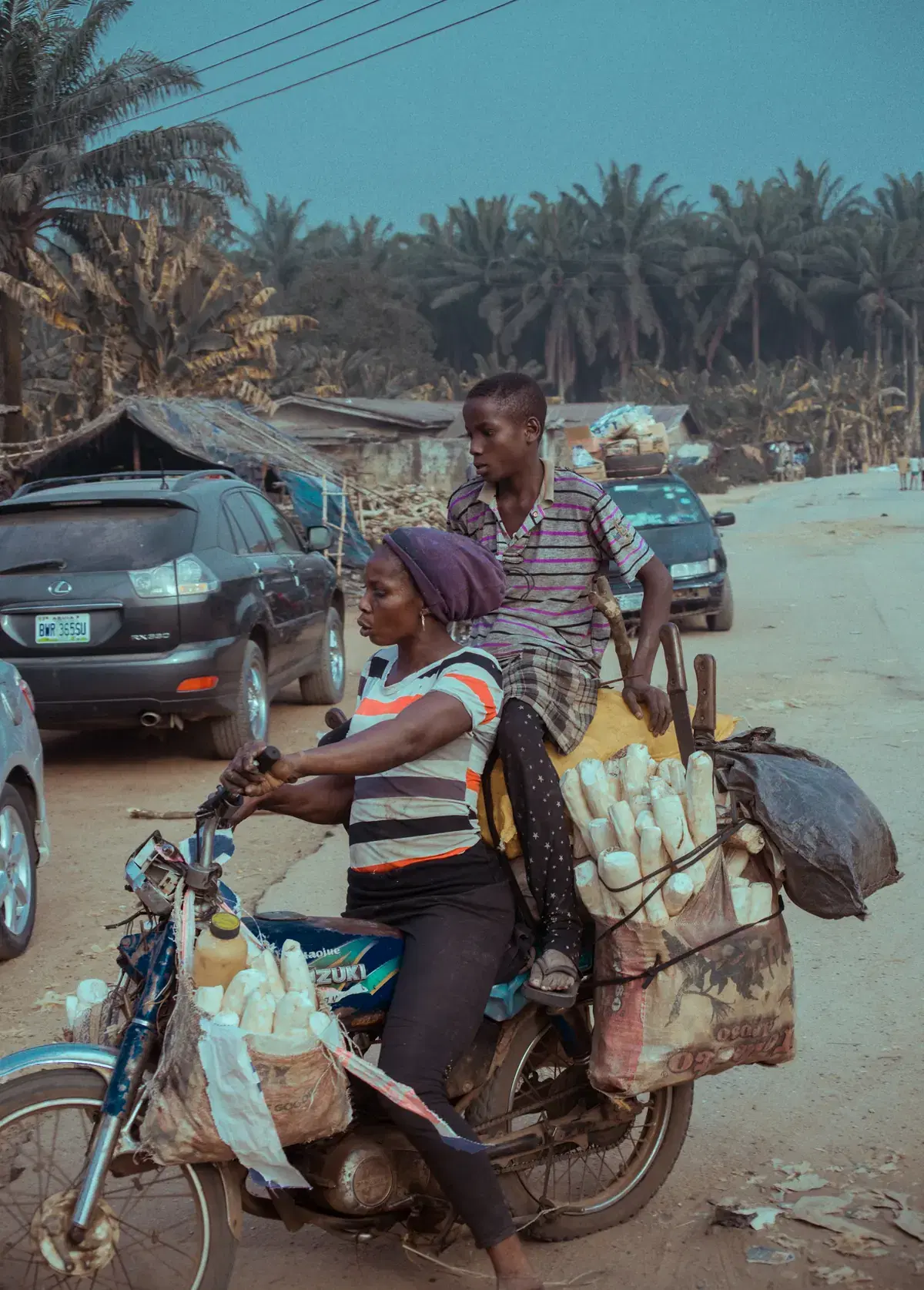 A rider carrying goods on a motorbike down a busy street