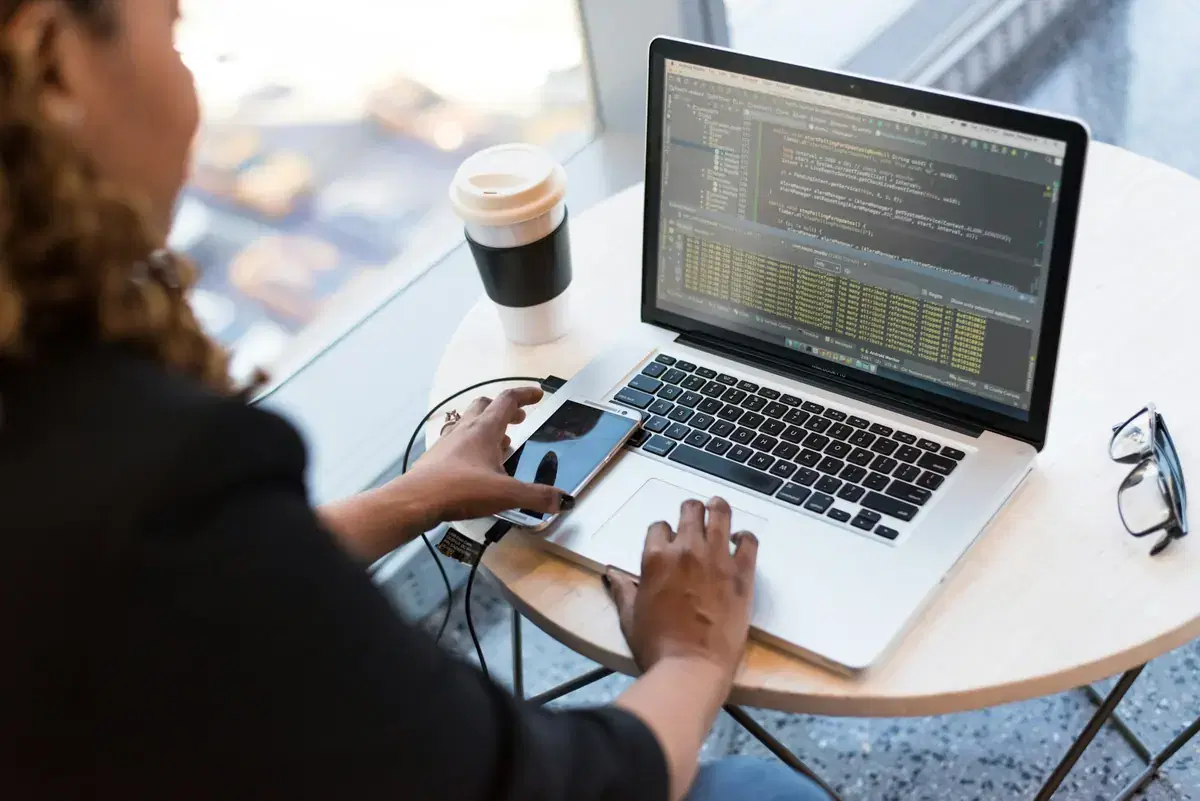 A developer writing code on a laptop