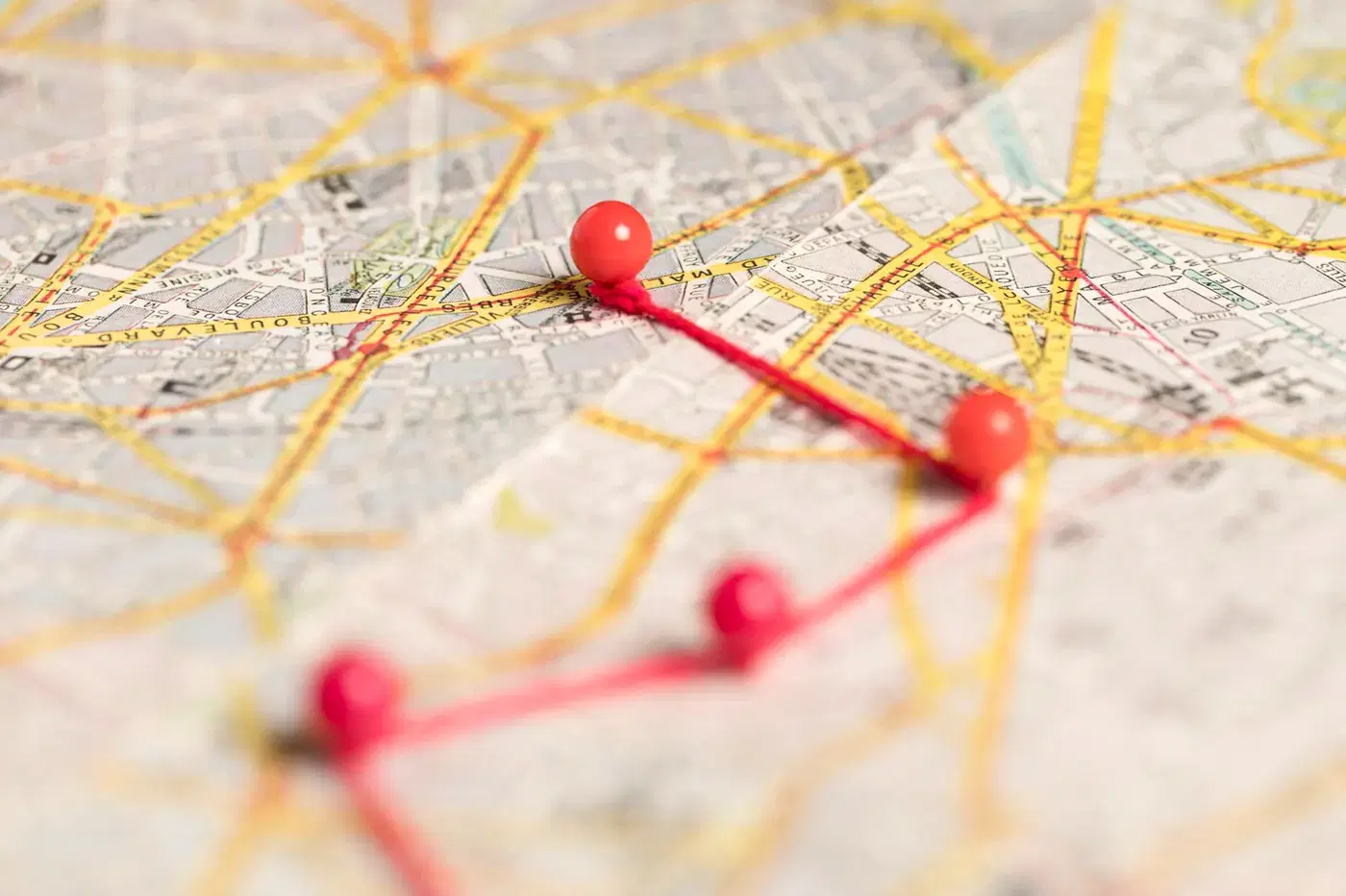 Red pins marking a delivery route on a paper map