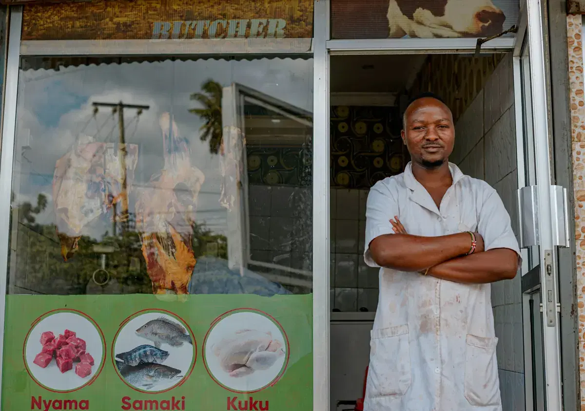 A shop owner standing proudly in front of his store