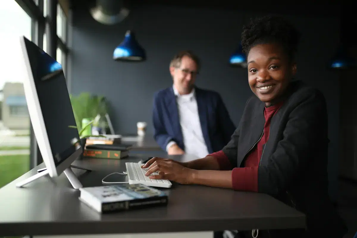 A smiling sales specialist at her desk
