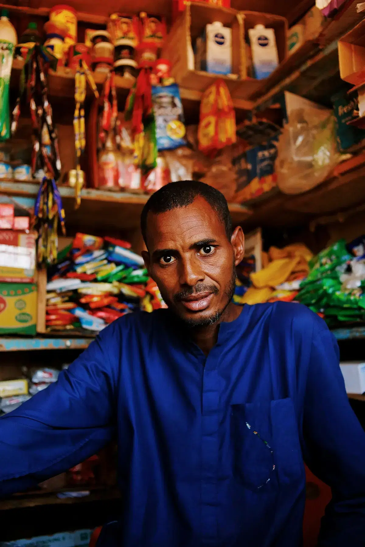 A shopkeeper standing in his well-stocked store