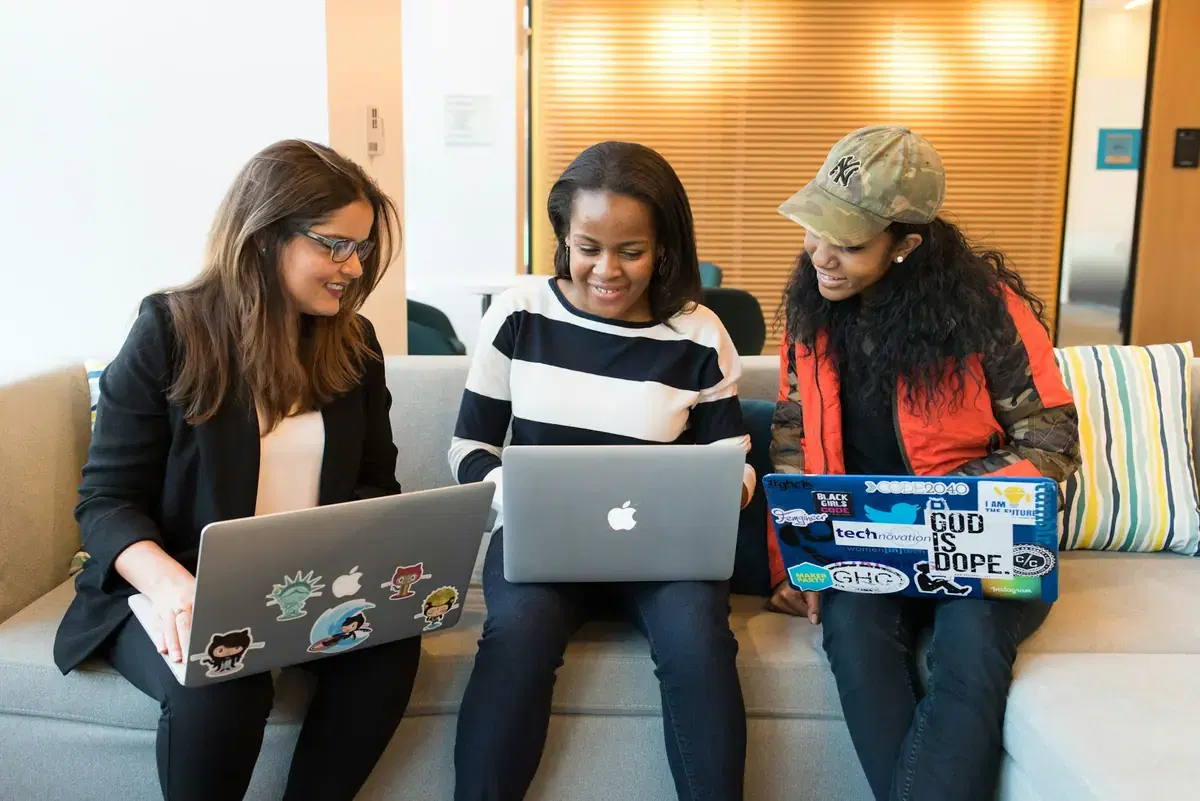 Three colleagues working together on laptops